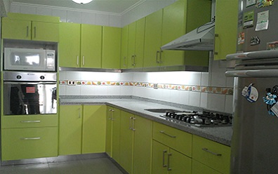 Muebles de cocina con puertas postformadas verde neon, cubierta de granito gris mara instalado en Santiago Centro