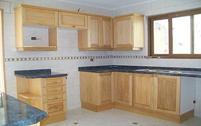 Proyecto de muebles de cocina con puertas de madera sólida de Mañio y cubierta postformada instalados en el Lago Rapel Sexta Region