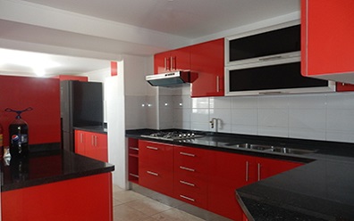 Muebles de cocina con puertas color rojo rubi, cubierta de granito negro San Gabriel instalado en Puente Alto