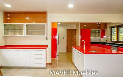 Vitrinas de aluminio vidrio saten, con mobiliario de cocina puertas blancas y rojas, las cubiertas de cuarzo rojo y negro galaxy fabricado en Puente Alto e instalado en Coyhaique