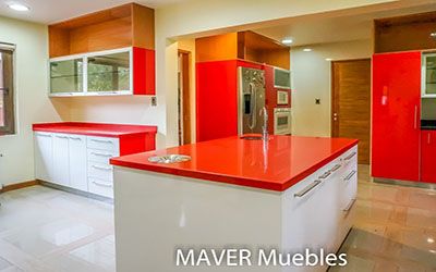 Basurero en Isla de cocina en acero inoxidable, cajones con sistemas cierre suave, bisagras y correderas puertas blancas y rojas con cubierta de cuarzo rojo y negro galaxy fabricado en Puente Alto e instalado en Coyhaique